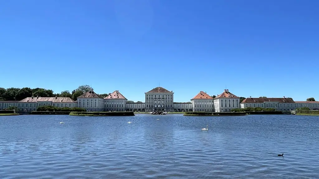 Blick über den See mit ein paar Schwänen auf das Schloss Nymphenburg