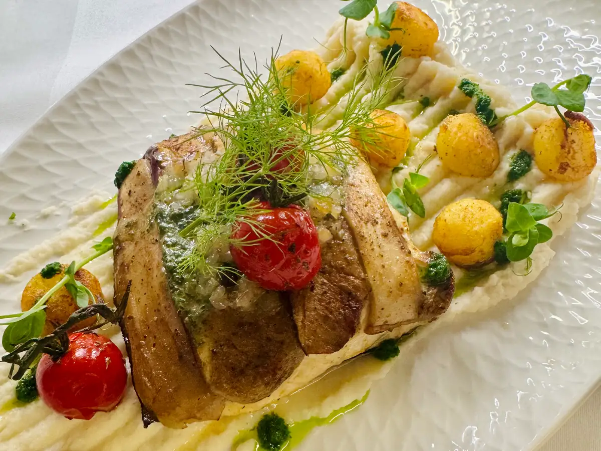 Steinbuttfilet in Steinpilzkruste auf Selleriepüree mit warmem Schmalzpesto, Peterislienöl und in Nussbutter glacierten Parisienne-Kartoffeln