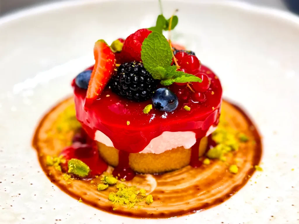 Zarter Matcha Sponge Cake mit Erdbeermousse und Himbeerglasur, dazu exotisches Sorbet von Mango und Passionsfrucht