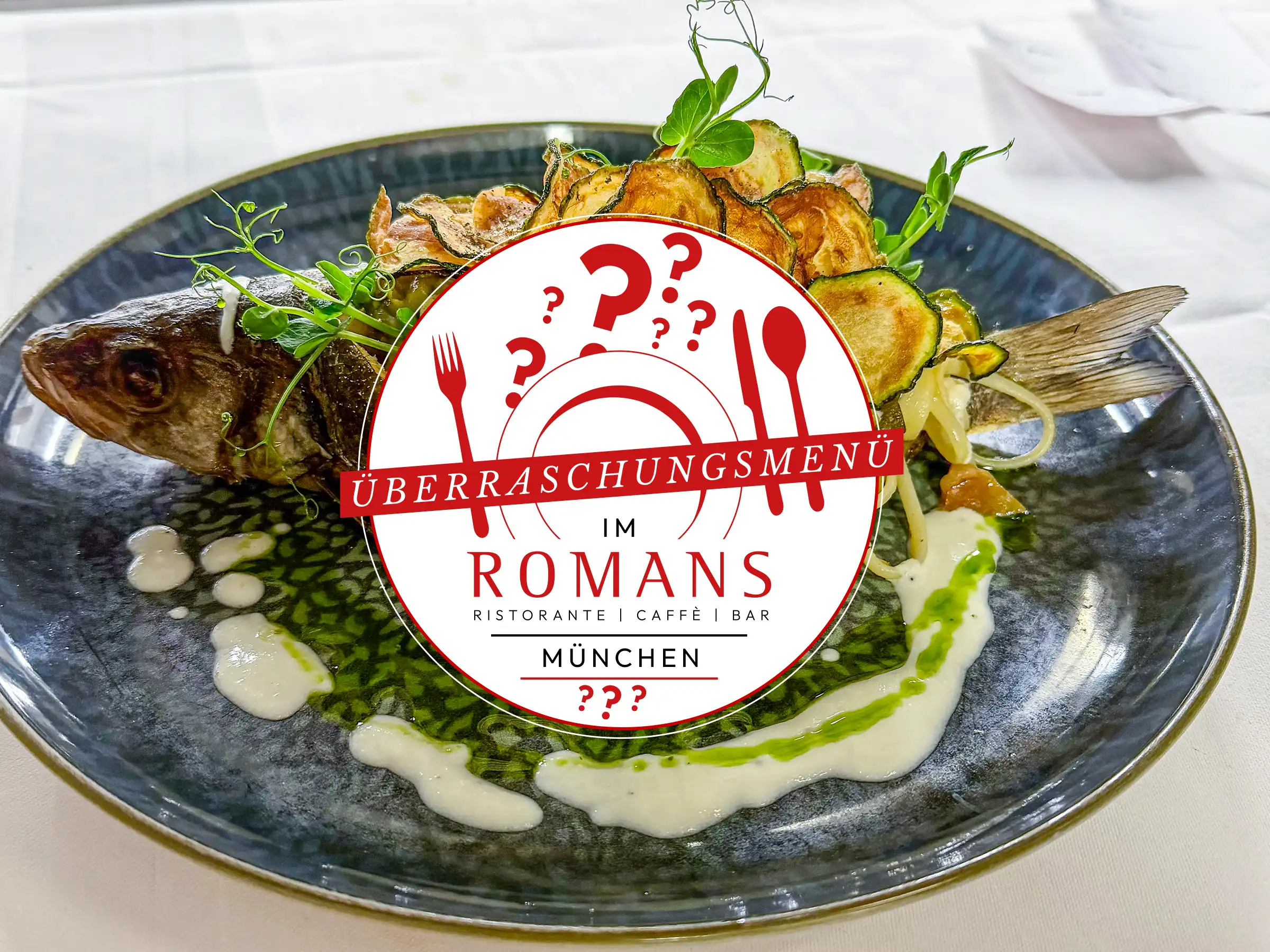 Ganzer gebratener Fisch mit Zucchinichips, Nudeln, Kr&auml;utern und Saucen auf einem dunklen Teller, dar&uuml;ber ein rundes Logo mit der Aufschrift &laquo;&Uuml;berraschungsmen&uuml; im Romans M&uuml;nchen&raquo;.